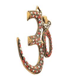 Brass OM wall hanging showing curved design and red/white gem inlay border