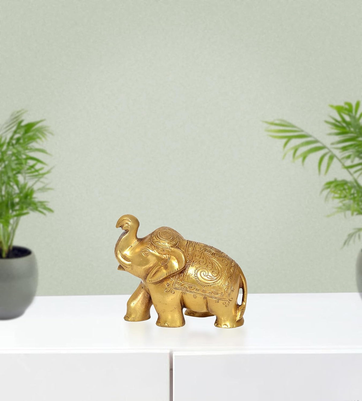 Brass elephant figurine with ornate engraved details, standing front view