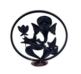 Black iron Ganesha idol showpiece in circular frame, sculpted profile with trident and flowers
