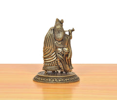 Brass Radha Krishna idol side view: patterned robes and flute, on round base