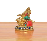 Brass Ganesha statue blowing conch shell, angled side view, jeweled blue-and-white band