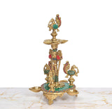 Brass peacock oil lamp stand with central figure, side peacock diya cups, teal base