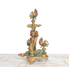 Brass peacock oil lamp stand with central figure, side peacock diya cups, teal base