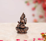 Copper Lakshmi idol statue from side angle, seated on lotus with ornate detailing