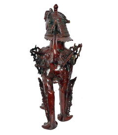 Temple lion statue, metallic dark red-brown finish, back view, winged cape and chain details