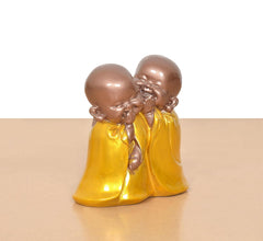 Resin laughing Buddha sculpture, two monks leaning together with smiling faces, yellow robes