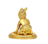 Brass Laddu Gopal idol statue, seated profile view, ornate crown and draped attire