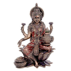 Bronze-finish Laxmi murti seated on lotus, ornate crown, raised hands and jewelry