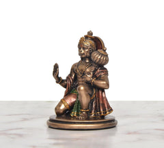 Resin Hanuman JI idol, side view—seated blessing pose with green skirt and gold details.