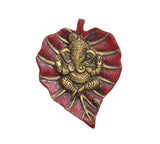 Metal Ganesha wall hanging close-up, heart-shaped red and gold relief figure