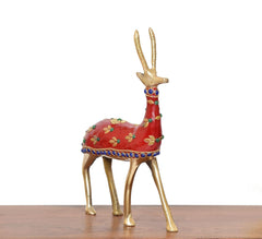 Brass reindeer statue with red body, multicolor floral accents, and blue jeweled belt