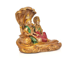 Side view of Vishnu and Lakshmi statue with gold headdress and green/red robes
