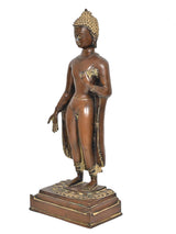 Brass standing Buddha statue side view, golden headdress and draped robe, on pedestal