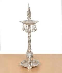 Silver metal peacock oil lamp stand with central pillar and hanging bell cups