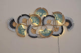 Iron botanical wall hanging with illuminated filigree leaves, teal-blue and dark gray