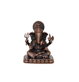 Seated Ganesha copper idol with four arms and ornate crown, dark base