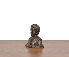 Copper Gowri Idol profile view, copper-tone figure with patterned hair and robe