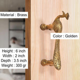 Gold brass peacock door handle on wood panel, screw-mounted bar handle