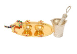 Gold-trimmed decorated plate with two brass bowls and silver cup holding pichkari