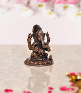 Copper Ganesha murti from angled rear view, seated posture on carved lotus base