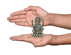 Brass Ganesha idol on lotus held in two hands, compact 3 in size