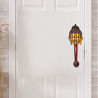 Buddha-face door handle with gold face details and red-brown stem