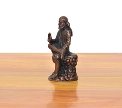 Shirdi Sai Baba statue side view, seated on textured base, hand raised