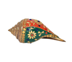 Brass shankh ornament, angled view showing teal back, gold trim, pointed tip