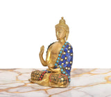 Brass Buddha idol seated in Abhaya mudra, blue gem-patterned robe, side angle