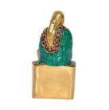 Brass Sai Baba statue, back view with green draped tunic and gold base