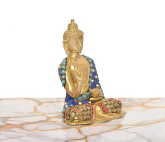 Side view of brass Buddha idol in Abhaya mudra, blue robe with turquoise accents