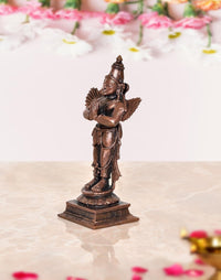 Copper Garuda idol statue side view, tall crown and folded hands with wing details