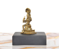 Side view of golden Mariamman Devi Durga idol on dark rectangular base