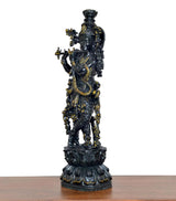 Lord Krishna figurine playing flute, rear three-quarter view, intricate dark brass detailing