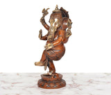 Brass dancing Ganesha idol in profile, four arms raised, standing on carved base