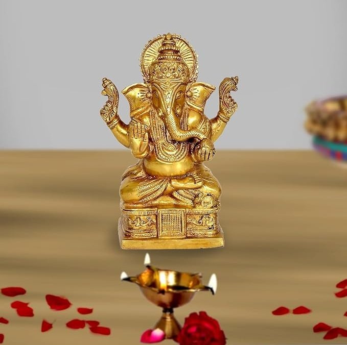 Brass Ganesh idol statue with raised hands, ornate crown, seated on a pedestal