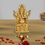 Brass Ganesh idol statue with raised hands, ornate crown, seated on a pedestal