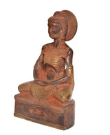 Brass Buddha statue idol from side angle, seated with halo and hands in lap.