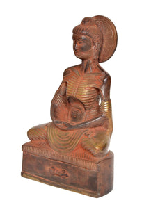 Brass Buddha statue idol from side angle, seated with halo and hands in lap.