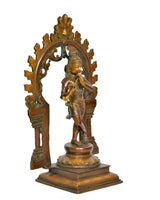 Brass Krishna flute-playing deity idol in embellished arched frame, full-body view