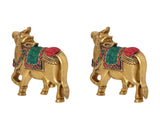 Brass Kamdhenu cow pair wall hanging, angled view with red headpiece and green trim