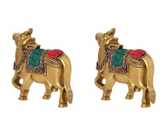 Brass Kamdhenu cow pair wall hanging, angled view with red headpiece and green trim