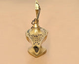 Brass genie lamp bottom view with central opening, chain loop, and engraved surface