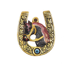 Gold metal horseshoe with painted horse head and blue eye bead at the base
