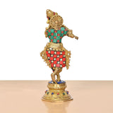 Rear view of brass Krishna flute statue, patterned green red outfit with jeweled ornaments