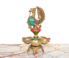 Brass peacock oil lamp with five diya bowls, sculpted stand and colorful accents