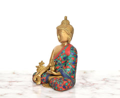 Brass Buddha statue in side view, multicolor floral robe and raised hand
