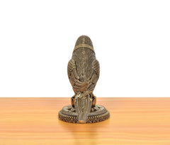 Brass parrot statue back view, vertical posture on circular base with carvings