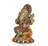 Brass Ganesha idol statue in side view, jeweled red, blue and green accents on outfit