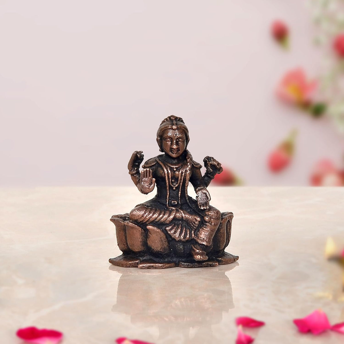 Copper Bala Tambika Sundari statue, seated child figure with raised hands, front view